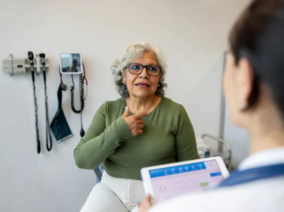 Latin American senior woman explaining her symptoms to a doctor in the consultation room