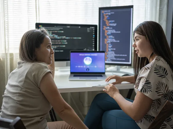 Two Female Programmers Learning To Code In Modern Office Using AI