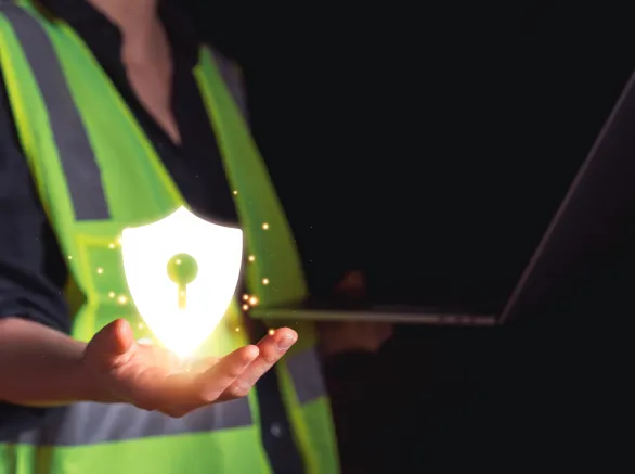 Industrial worker in safety vest holding glowing shield icon with keyhole
