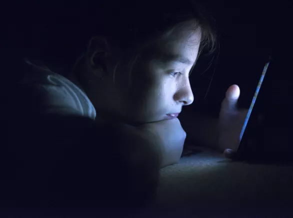 Kid using smart phone in a dark room