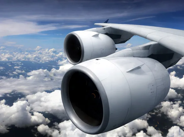 Airplane turbine engine from window view with cloudy sky