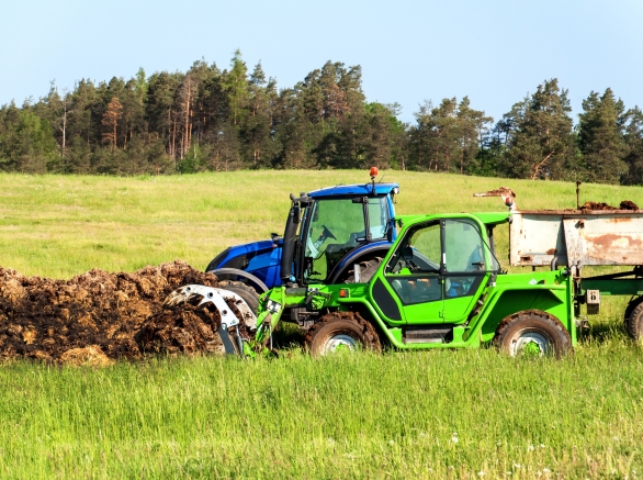 Loading Manure onto a tractor in a field