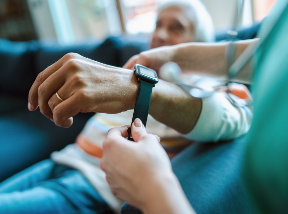 An elderly patient being fitted with a digital health wrist wearable