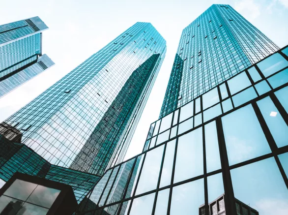 Close up view of glass building sky rise with blue sky above