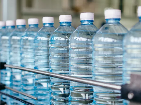 Plastic water bottles moving through a production line.