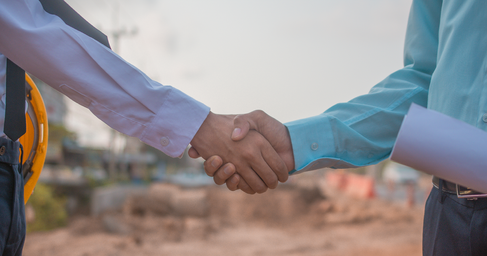 Businesspeople shaking hands in agreement. Exponent engineering expertise for construction disputes.