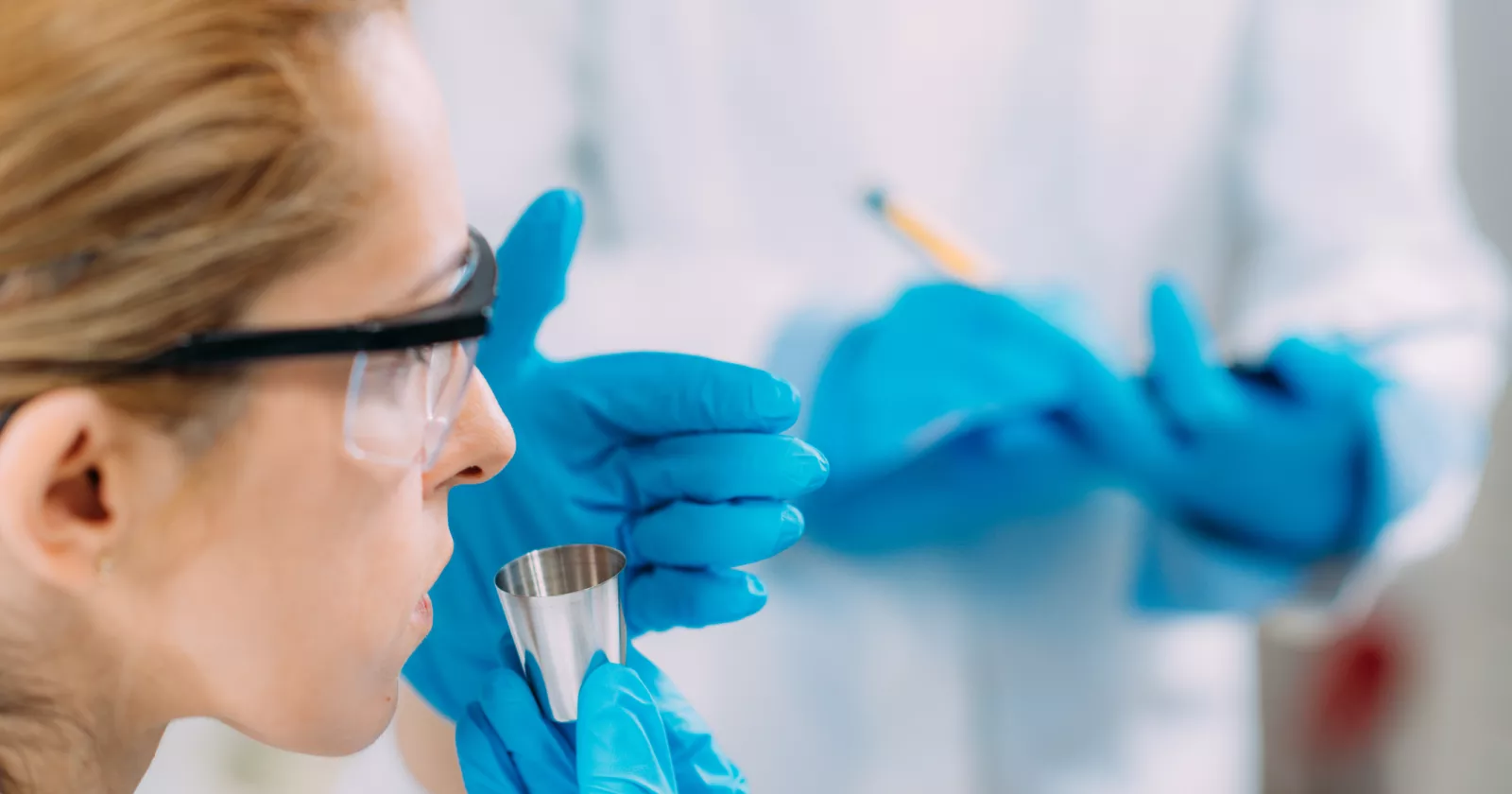 Scientists Smelling a Sample in the Test Cup