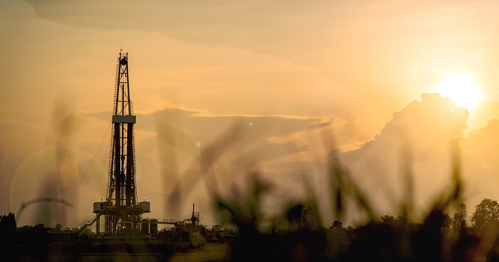 Oil derricks in the sunset and dust. Exponent environmental engineers help clients analyze risk and project costs. 