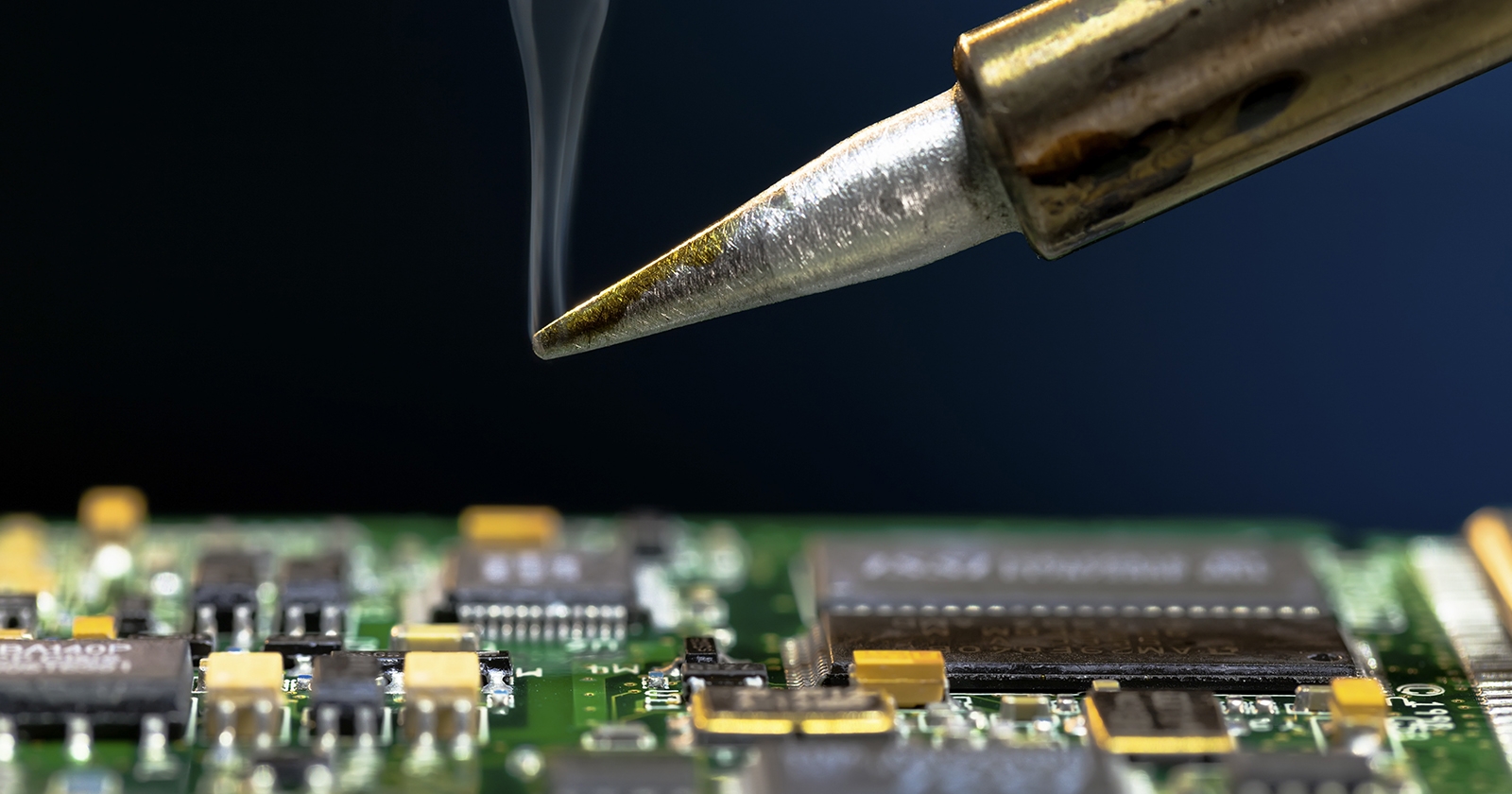 An expert analyzes a circuit board. Exponent engineers provide expert analysis of discrete components & printed circuit boards​