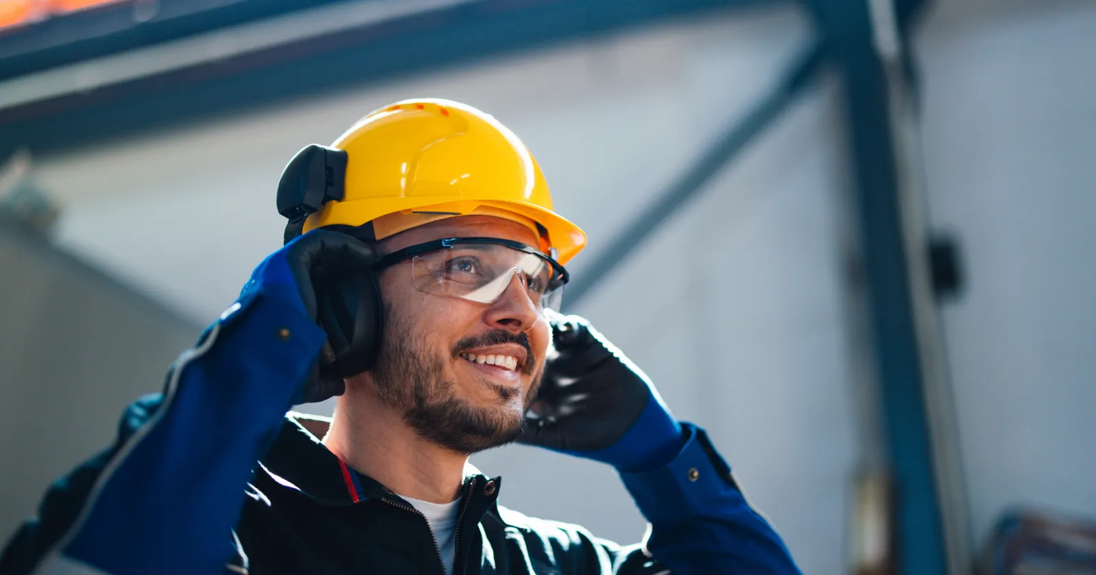 Smiling Worker in Safety Helmet Communicating in Factory