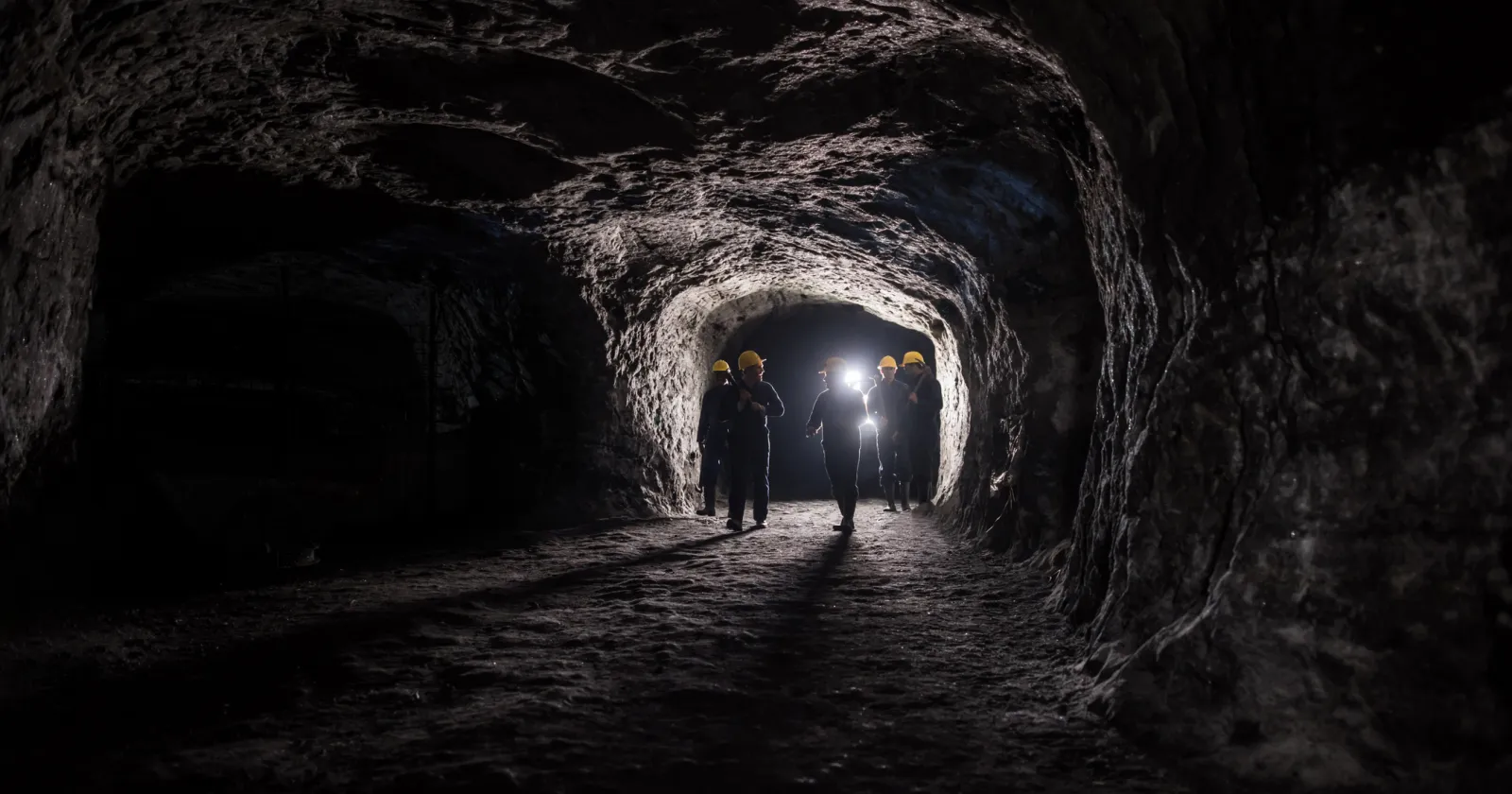 Group of men in a dark mine underground - mining concepts