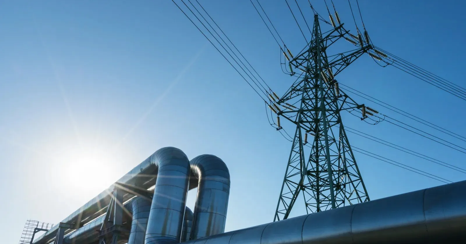 Industrial pipelines on pipe-bridge against blue sky