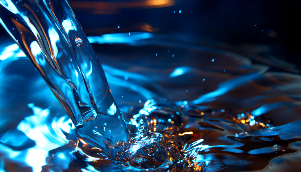Water flowing into bucket of blue water