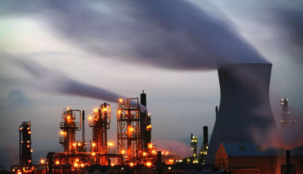 An energy facility of multiple reactors with smoke billowing from the top 