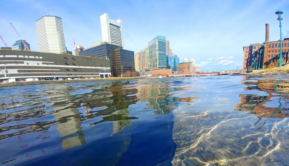 A body of water by the side of a downtown city area