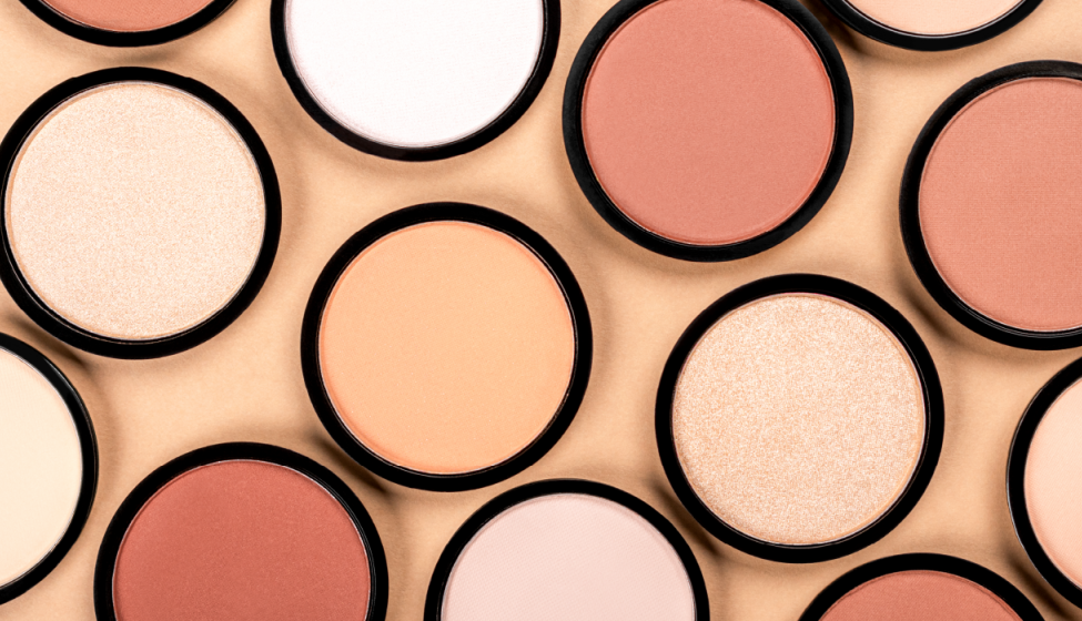 Close-up of multiple round powder cosmetic containers in varying shades