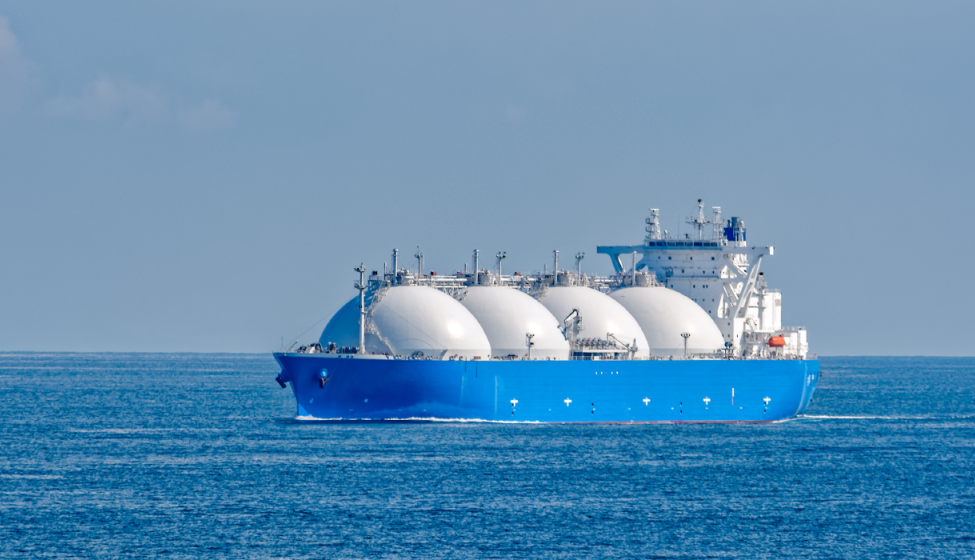 Blue ship with four rounded LH2 canisters afloat in the ocean