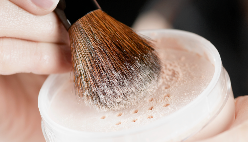 Makeup-brush rubbing against powdered make-up in small round container