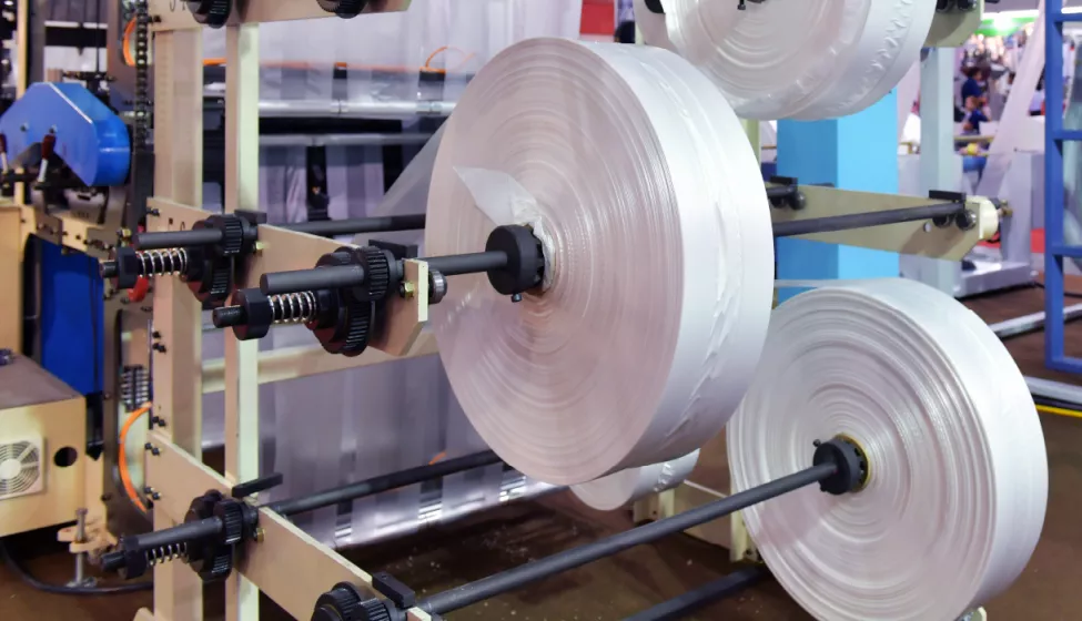 3 large rolls of plastic packaging in a packaging plant