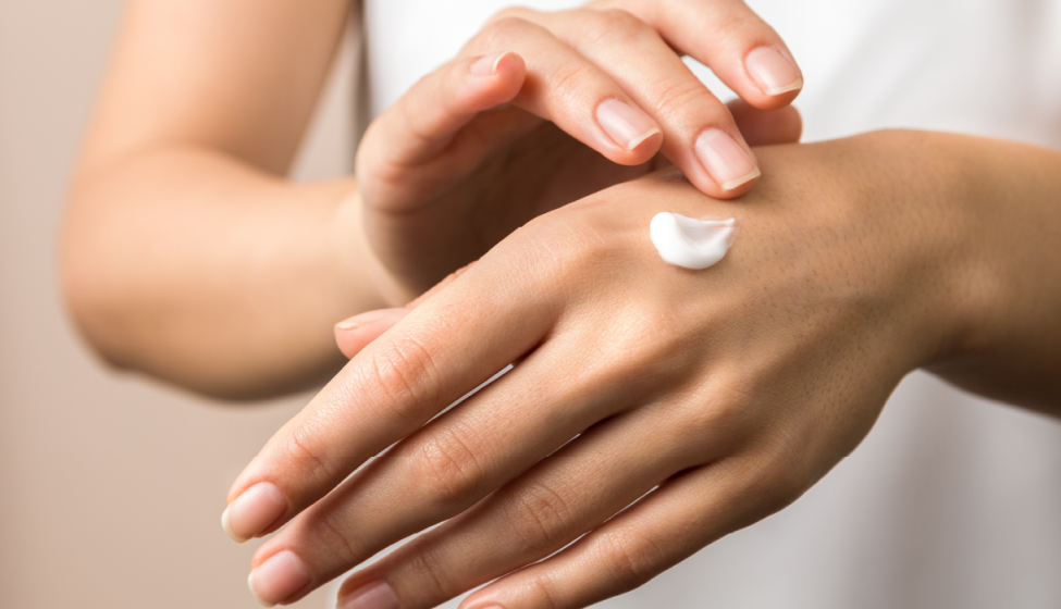 A woman applies hand cream 