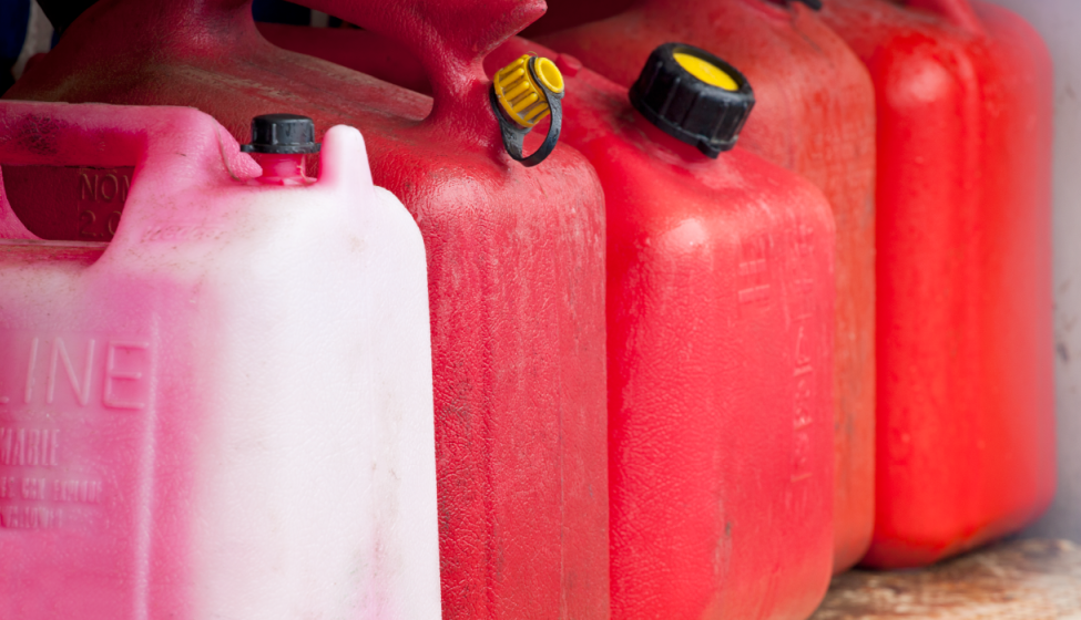 Close up of five red plastic fuel containers lined up side by side