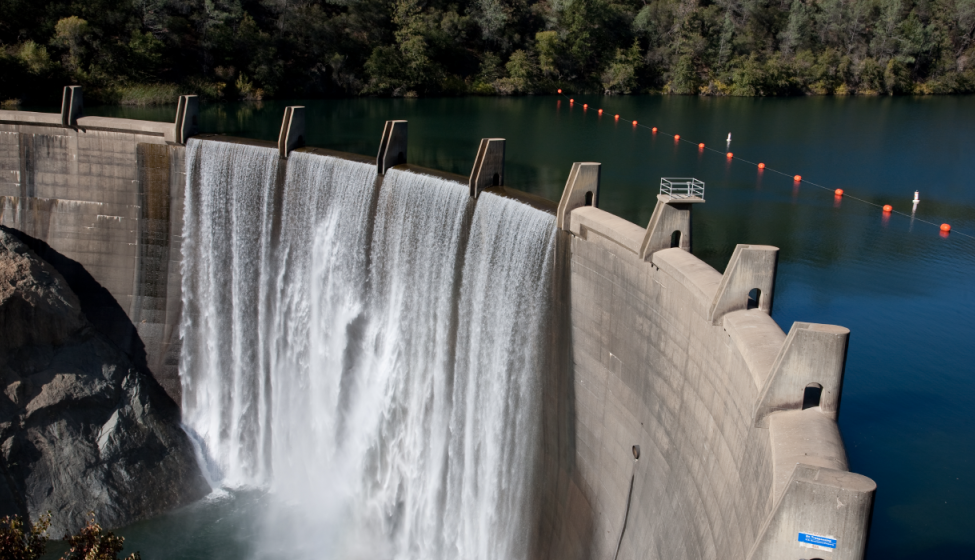 Aerial view of water cascading over a concrete dam wall