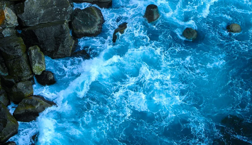 Blue waves of the ocean near the rocks. 