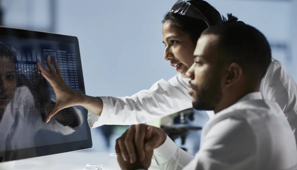 Scientists Working on Computer In Modern LaboratoryNOTE TO INSPECTOR: all graps, dna models, charts are made by me