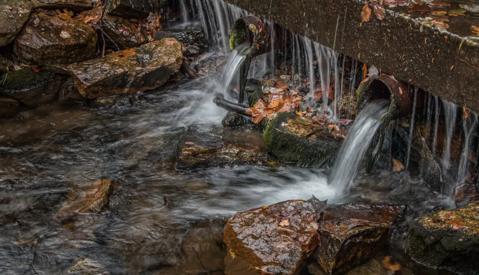 Stormwater flows from pipes into a stream