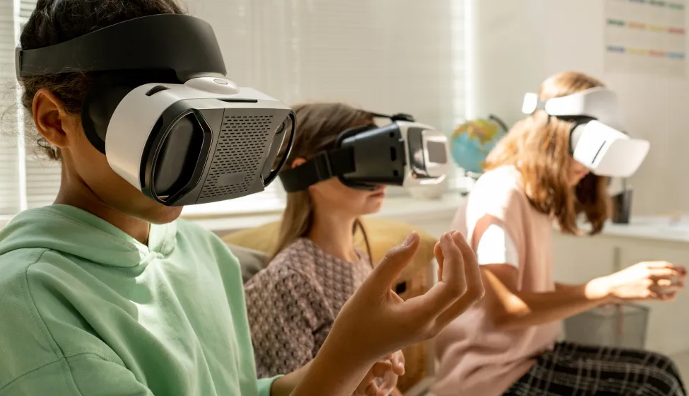 Schoolgirls in goggles holding invisible virtual objects