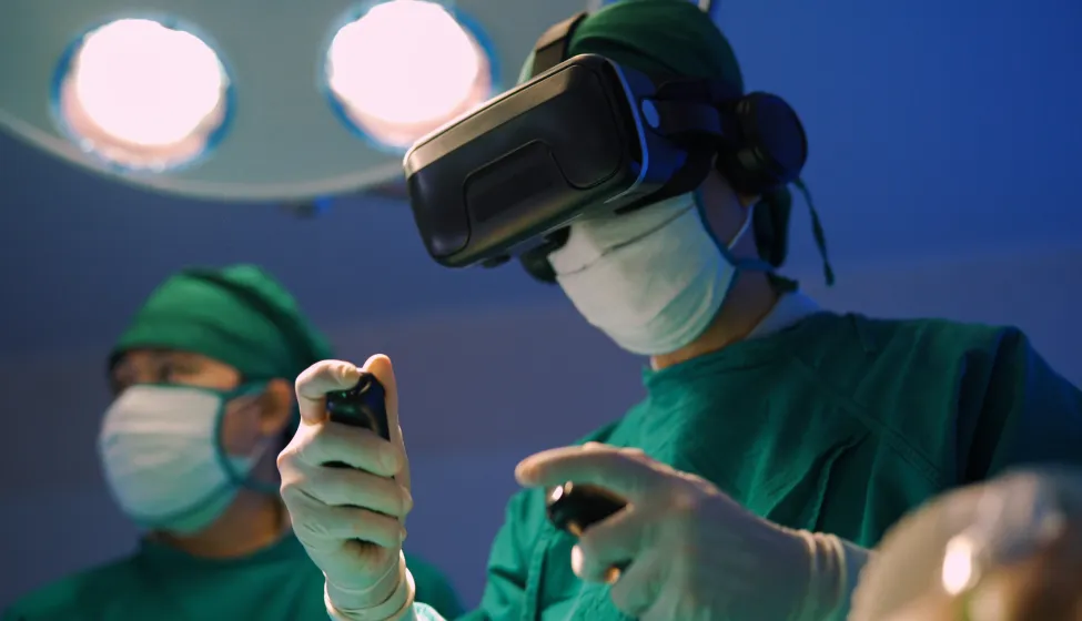 Professional surgeons in uniform and VR headset performing operation on patient in modern clinic.