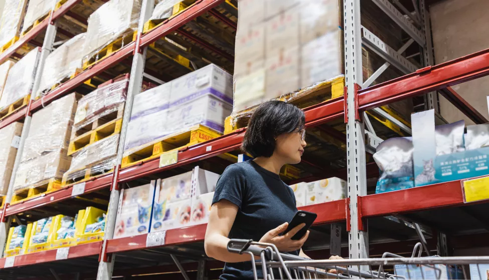 Shopper walking down the aisle of a wholesale warehouse store