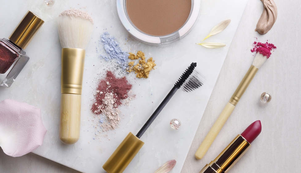 Various makeup products scattered around a flat white surface