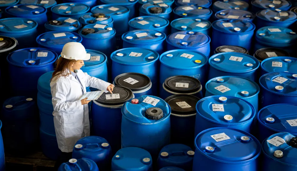 Foreperson doing quality control on a stock of chemical barrels 