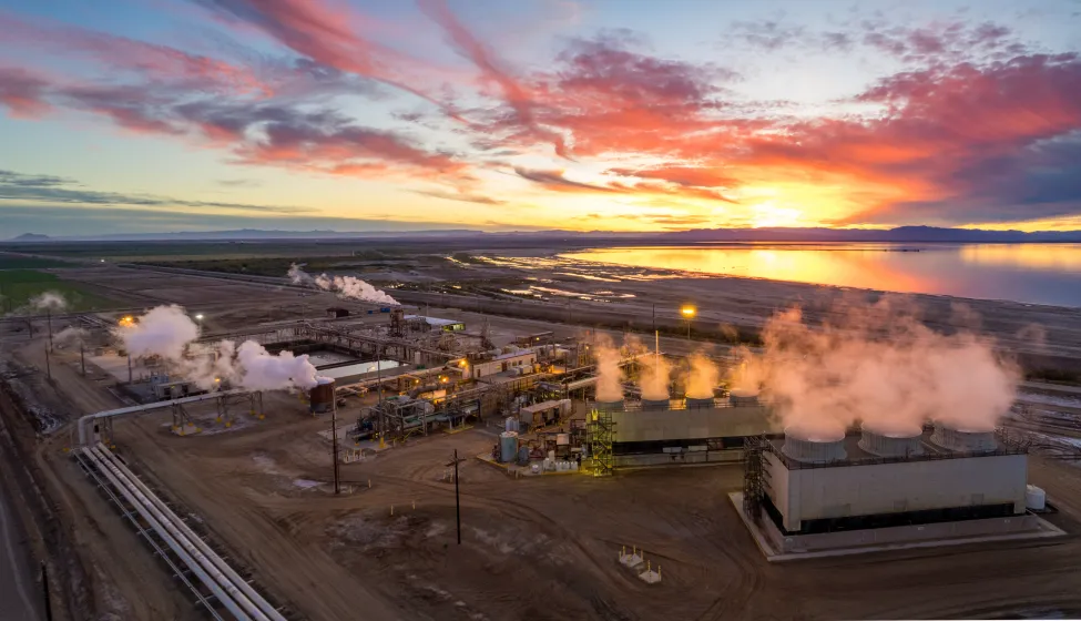 Aerial view of steam rising above an industrial Geothermal Power Plant, Salton Sea in the distance