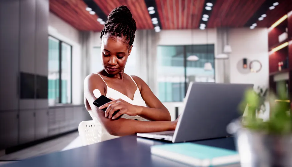 Woman Testing Glucose Level With Continuous Glucose Monitor On Mobile Phone