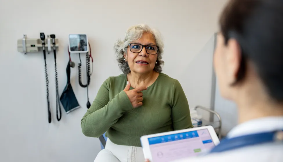 Latin American senior woman explaining her symptoms to a doctor in the consultation room