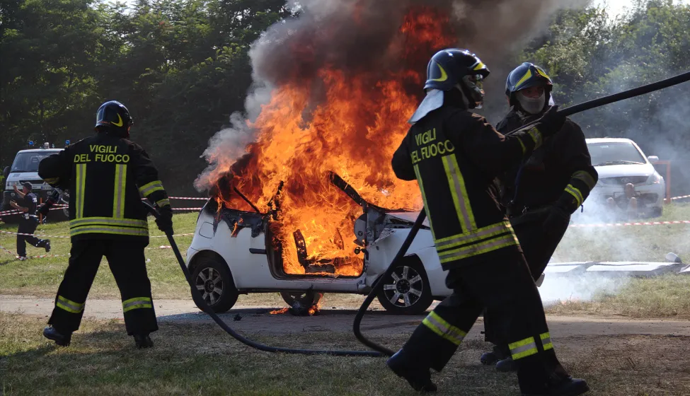Firefighters extinguishing car on fire