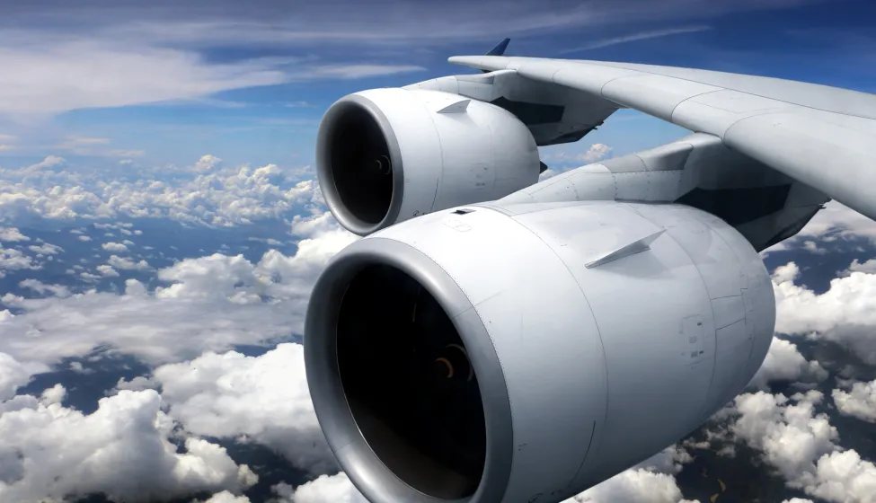 Airplane turbine engine from window view with cloudy sky