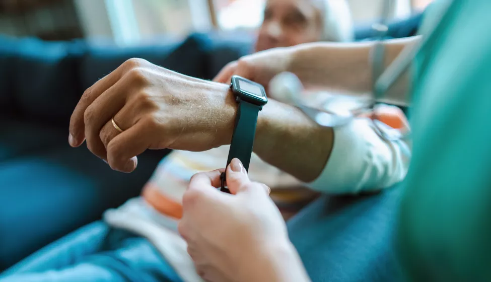 An elderly patient being fitted with a digital health wrist wearable