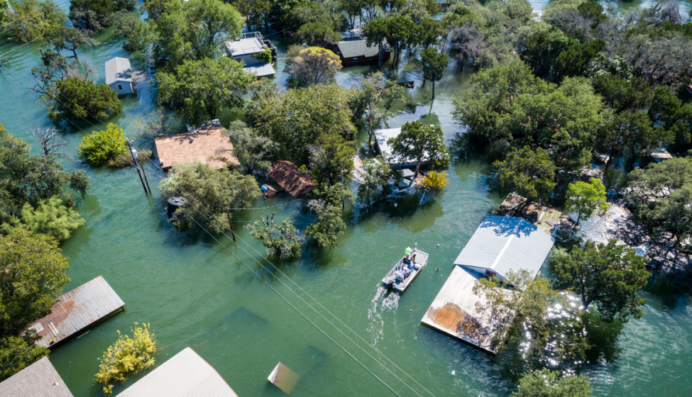 Aerial view of homes flooded after a storm with a rescue boat nearby