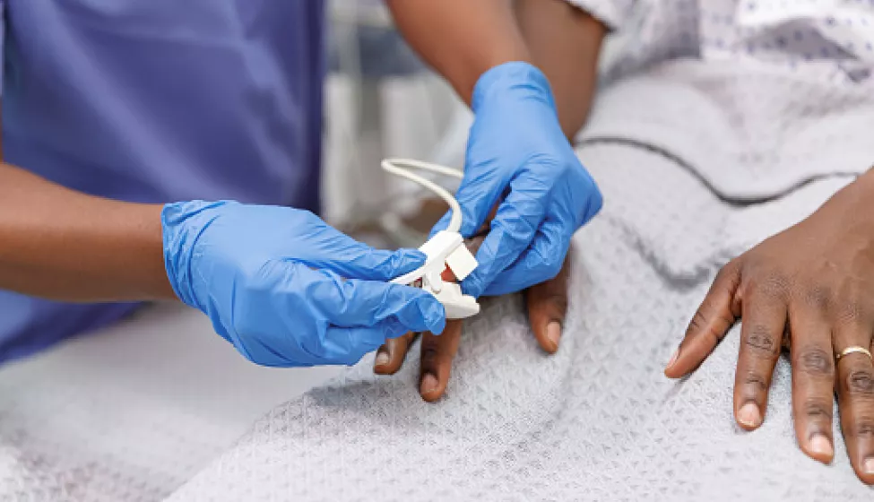 Nurse using pulse oximeter on hospitalized patient