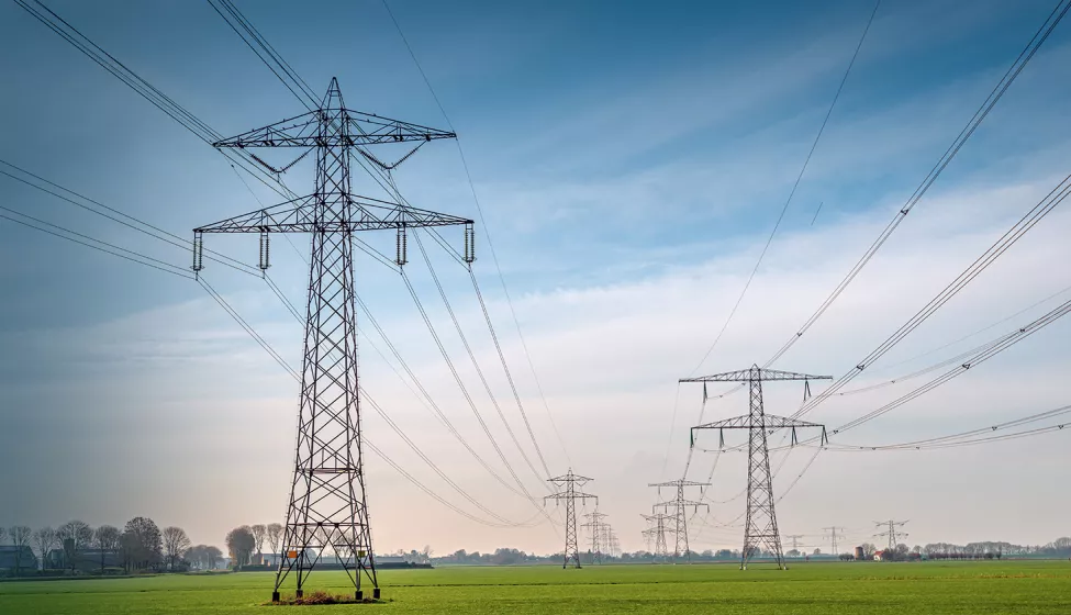 Large powerlines in a rural farm setting. Exponent helps stakeholders explore safer, more efficient and alternative energy solutions. 