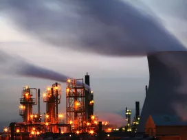 An energy facility of multiple reactors with smoke billowing from the top 