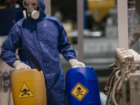 Worker handles hazardous materials. Exponent consultants provide technical expertise for chemical safety and compliance.