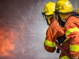 Firefighters work to extinguish flames.  Exponent fire protection engineering helps create fire prevention strategies.