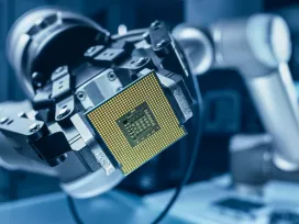 A robotic arm holding a computer chip. Exponent provides Electrical Engineering & Computer Sciences expertise for all industries. 