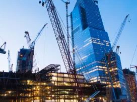 Skyscrapers surrounded by industrial cranes. Exponent technical support for construction claims.